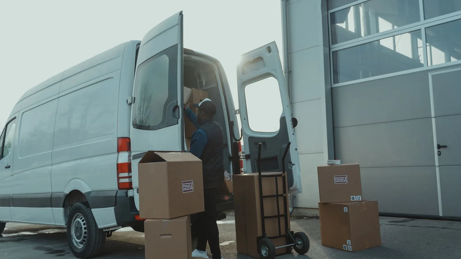 Person loading cardboard boxes into an open moving van